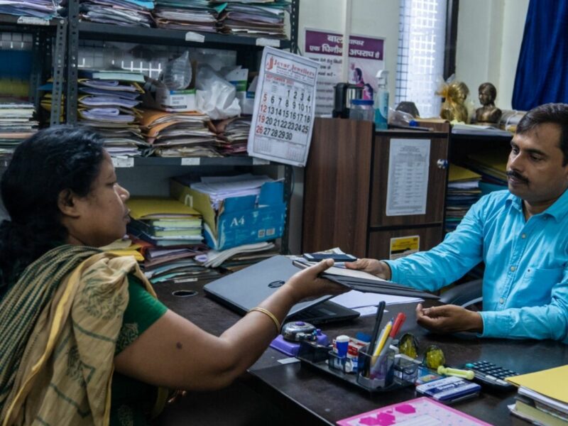 The District Child Protection Officer (DCPO), Mr Altaf (right), checks the details about a family’s situation recorded in the KoBoCollect app by our partners, CINI India, at his office.