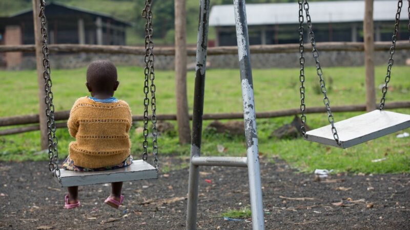 A picture of a child sitting on a swing alone, from our programmes in Rwanda