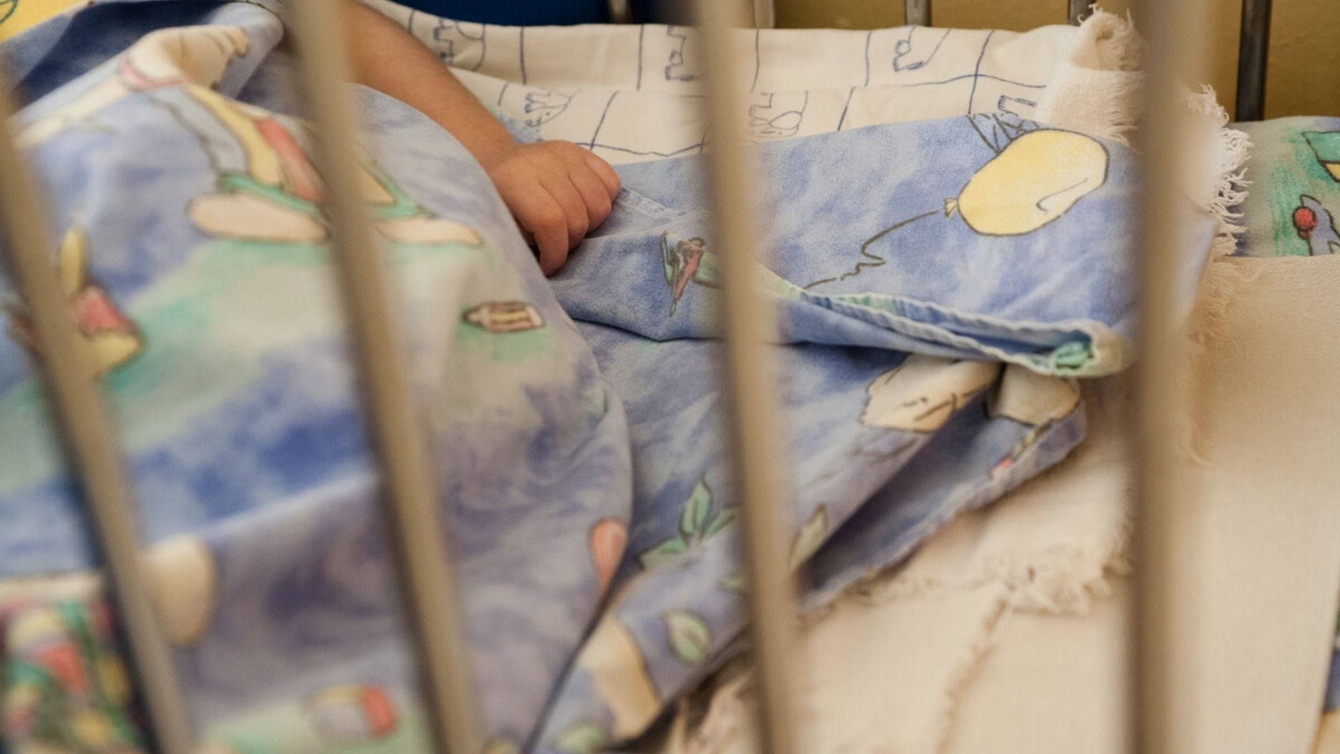 A child behind the bars of a cot in an orphanage in Bosnia
