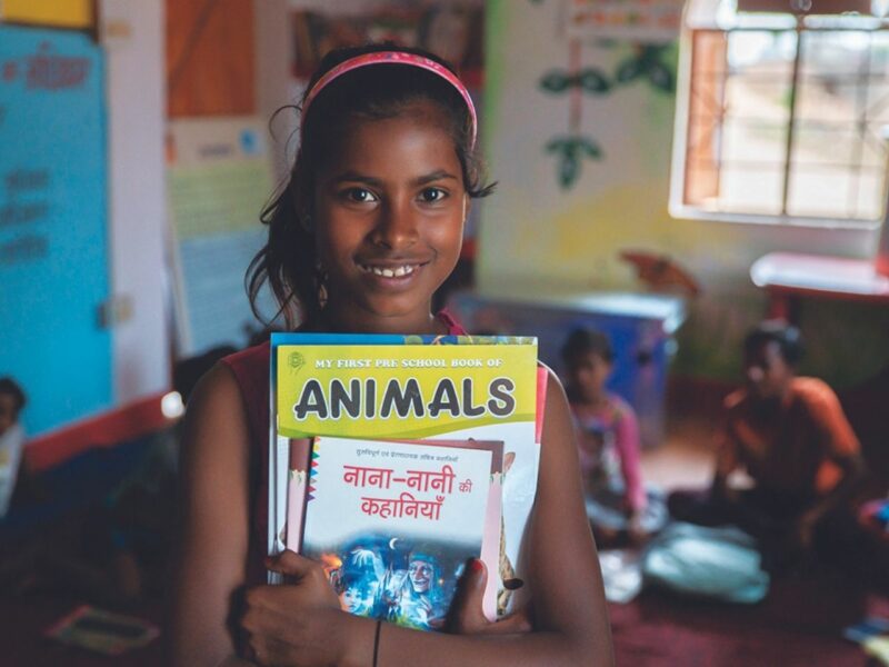 Jacinta holding her school books and smiling