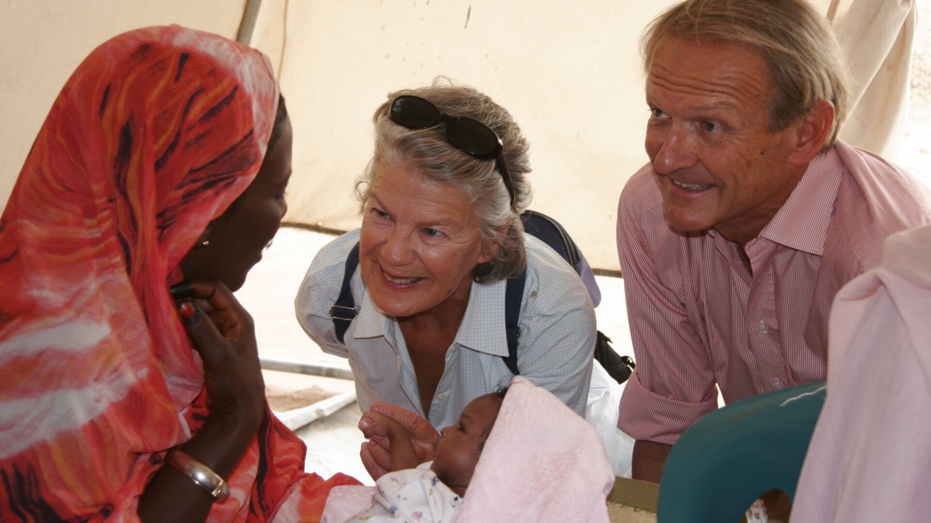 Mark and Caroline Cook, our founders, listening to a child