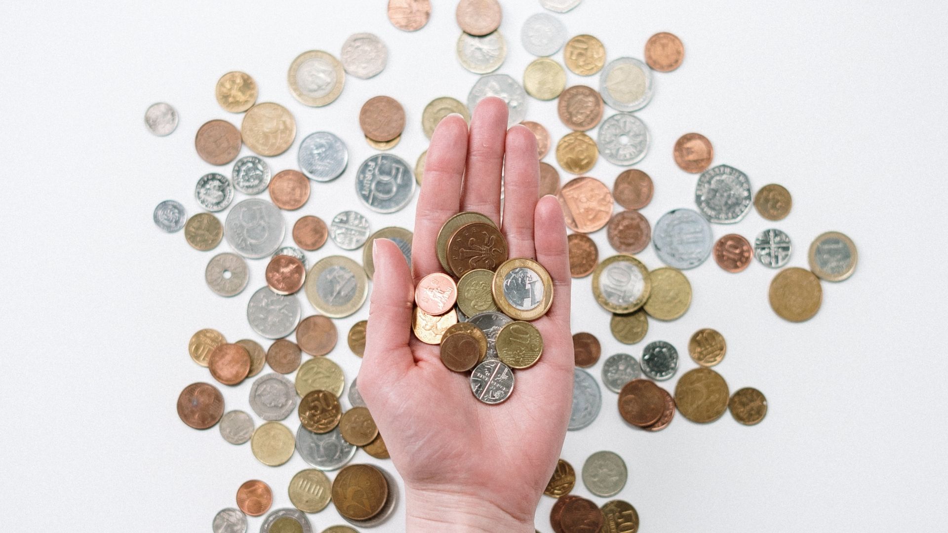 A hand surrounded by coins
