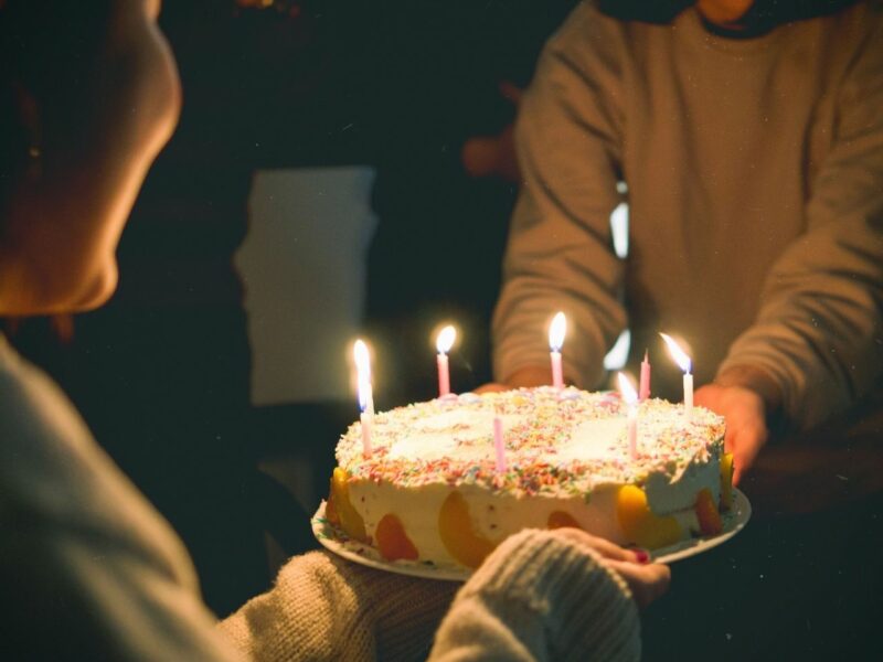 A person blowing out the candles on a birthday cake