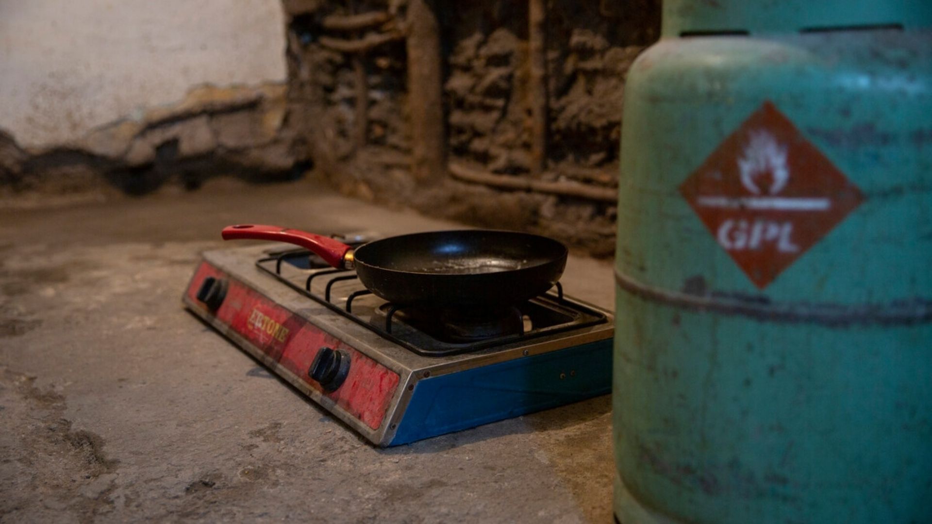 A gas canister in the foreground used to fuel the cooker on the floor. This is in the home of one of the families we work with in Romania