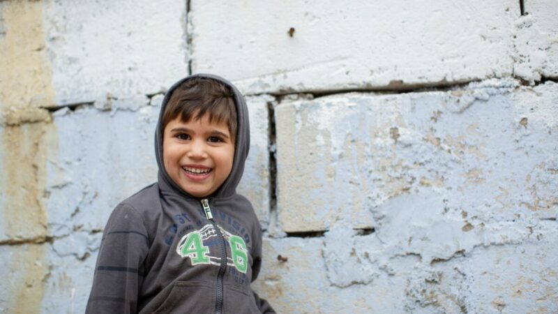 A portrait of a little boy smiling. He is part of one of the families we are supporting in Romania