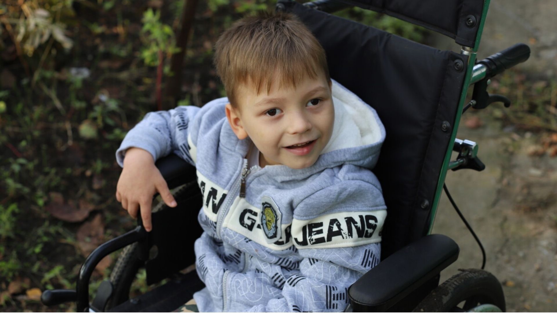 Vasilica, a little boy from Moldova, in a wheelchair