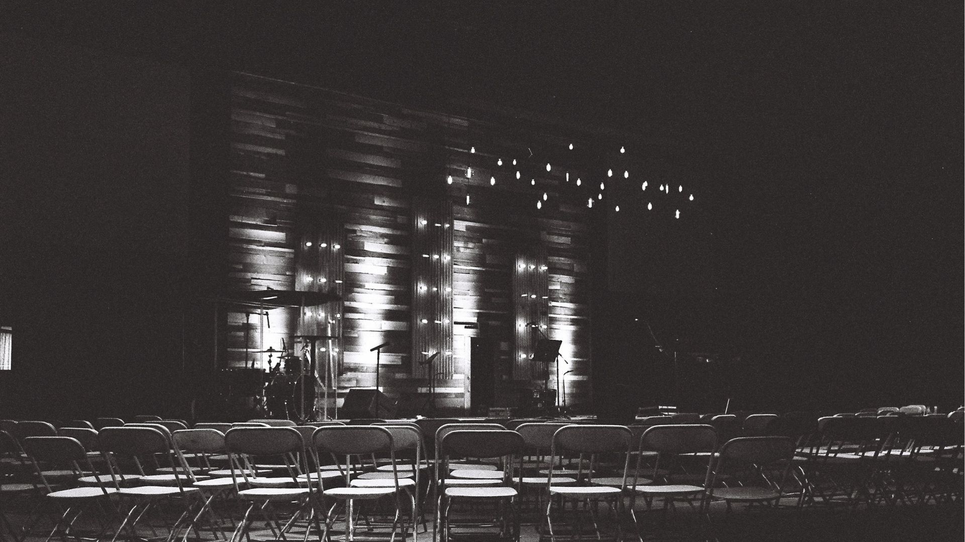 An empty venue with lots of chairs, in black and white