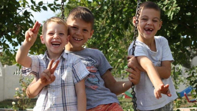 Three Moldovan boys on a swing