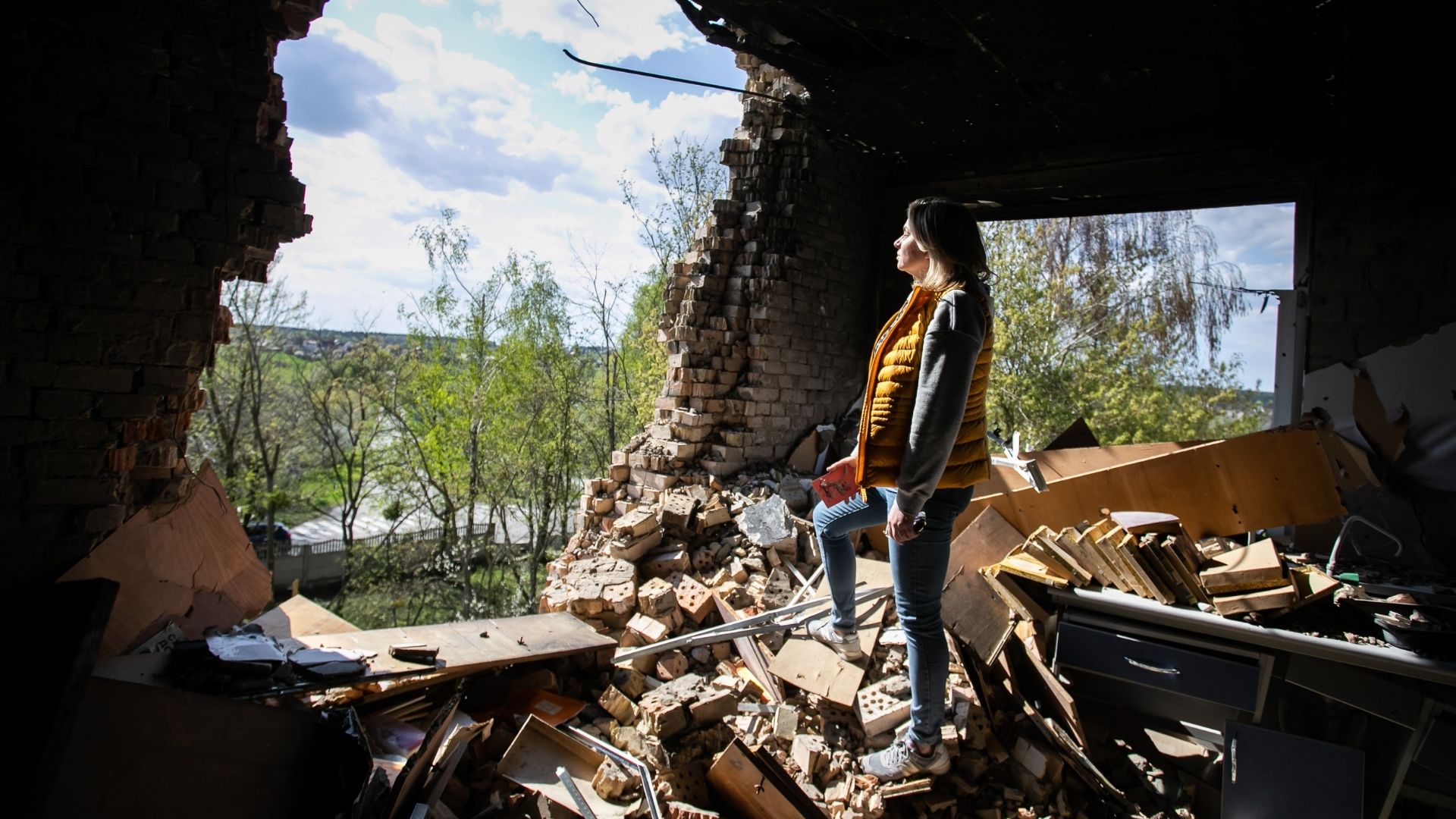 Halyna Postoliuk, our country director for Ukraine, standing in a school that has been destroyed by bombing