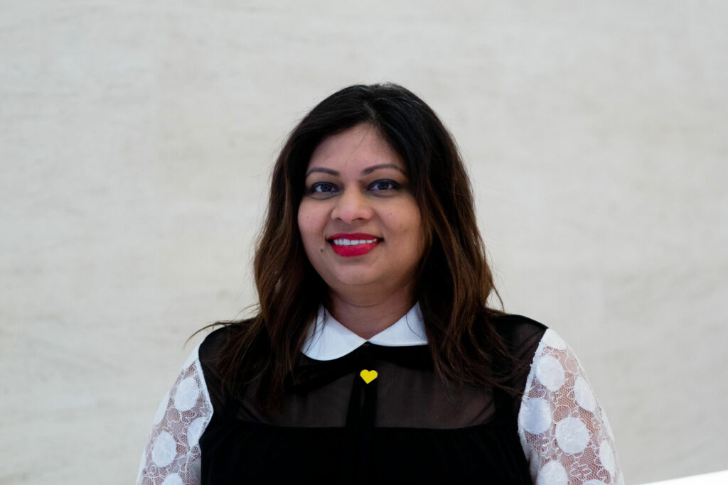 Trustee Ruchira Neotia turns and looks confidently towards the camera in a white polka dot shirt with black top