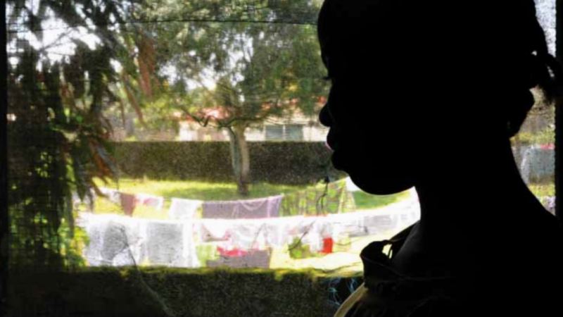 Silhouette of a child looking out a window