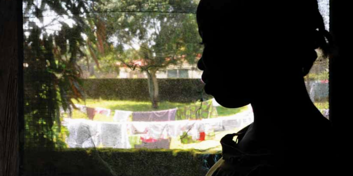 Silhouette of a child looking out a window