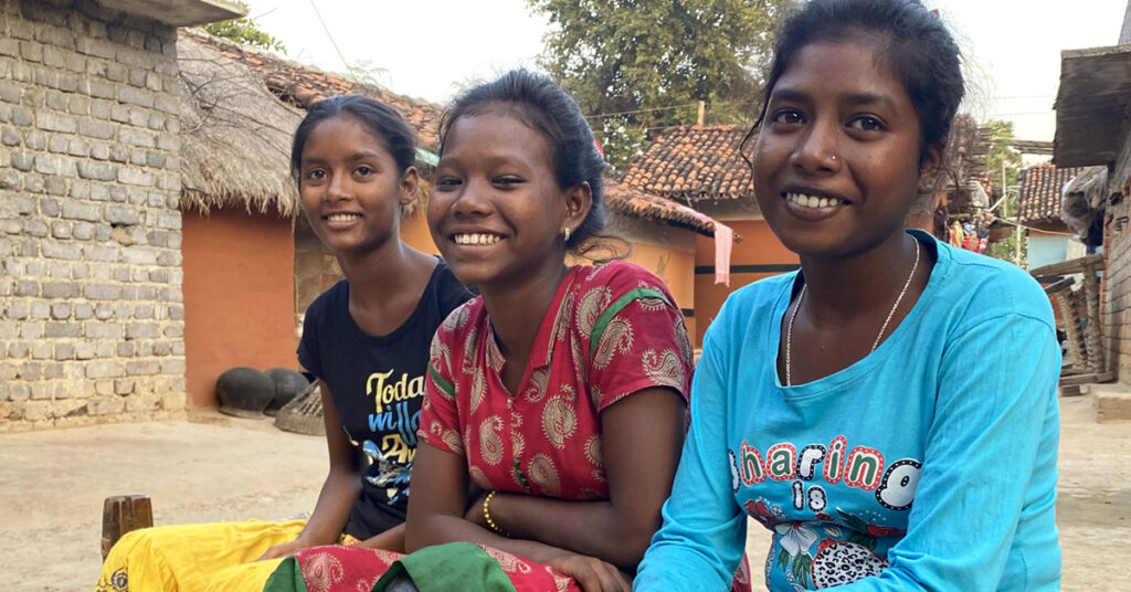 Devis siblings sitting with her outside her house