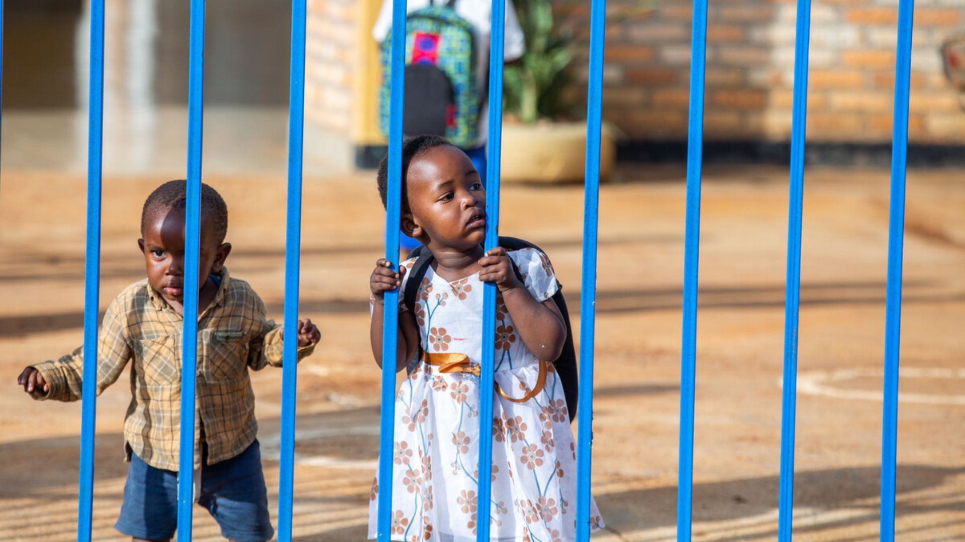 Children leaning on the bars when it's time to go home at an inclusive Community Hub in Gatsibo District, Eastern Province, Rwanda, in June 2022.