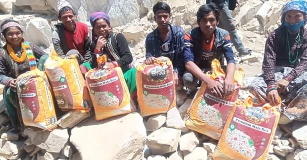 Parents of reunified children sit with bags of rice in a village in Humla.