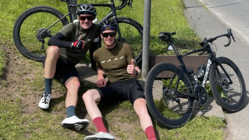 Jonathan and his brother having a rest on the grass beside their bikes