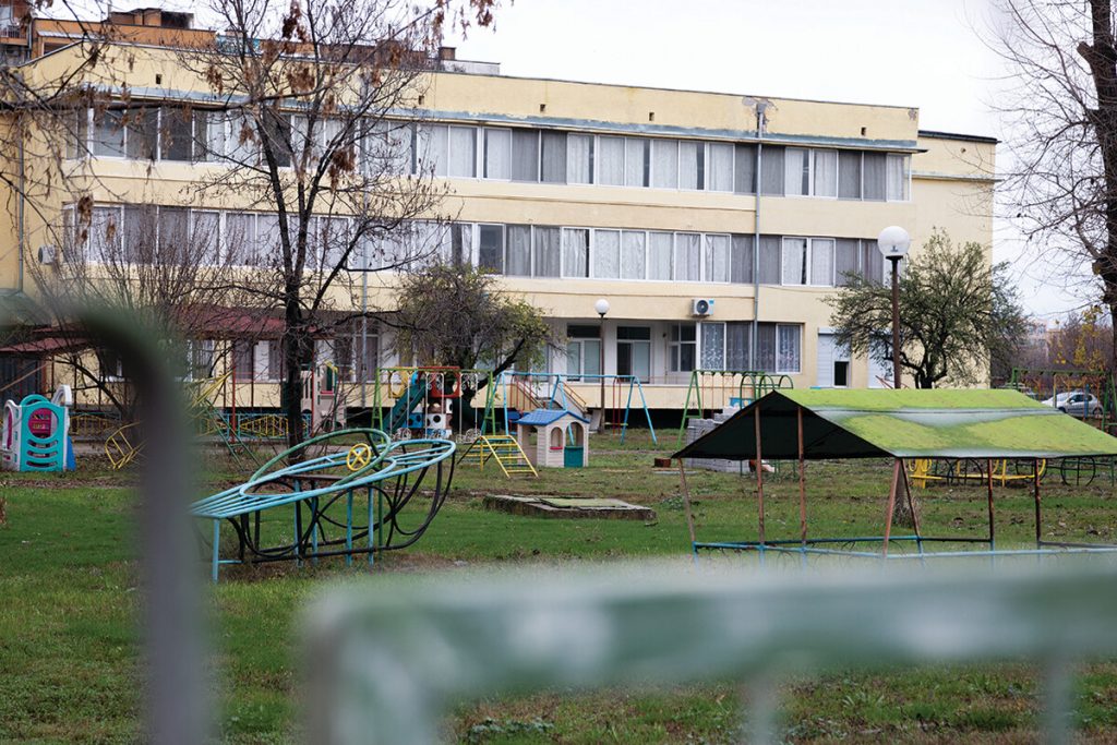This is a photo of a children's institutional building in Bulgaria with a chidren's play area