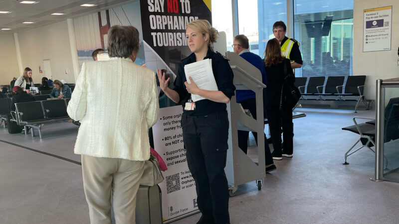 Border force agents speaking with a traveller in London Heathrow airport