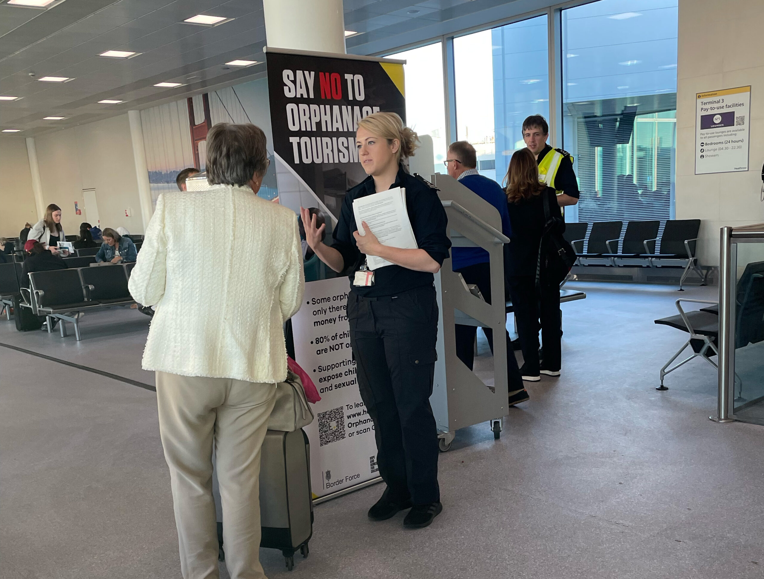 Border force agents speaking with a traveller in London Heathrow airport