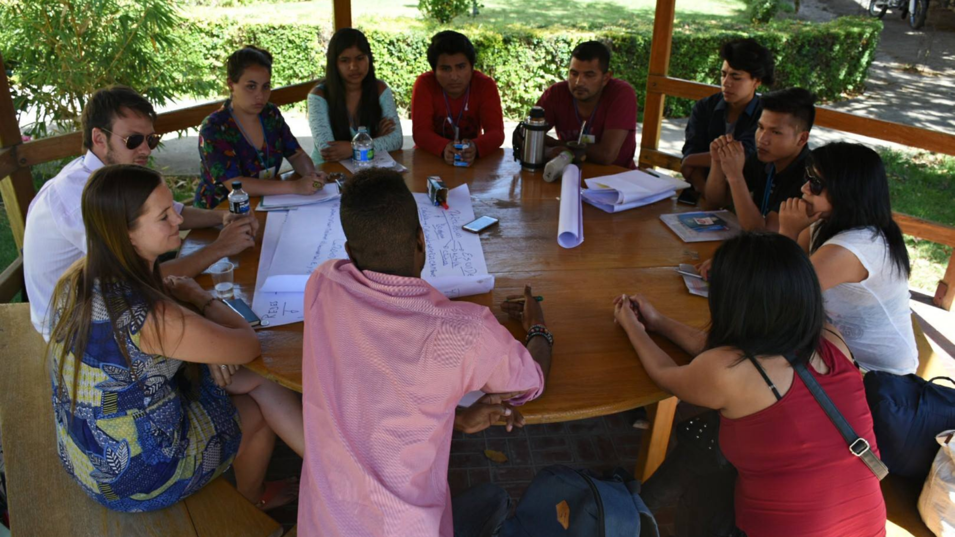 Group of young people sat around a table having a discussion