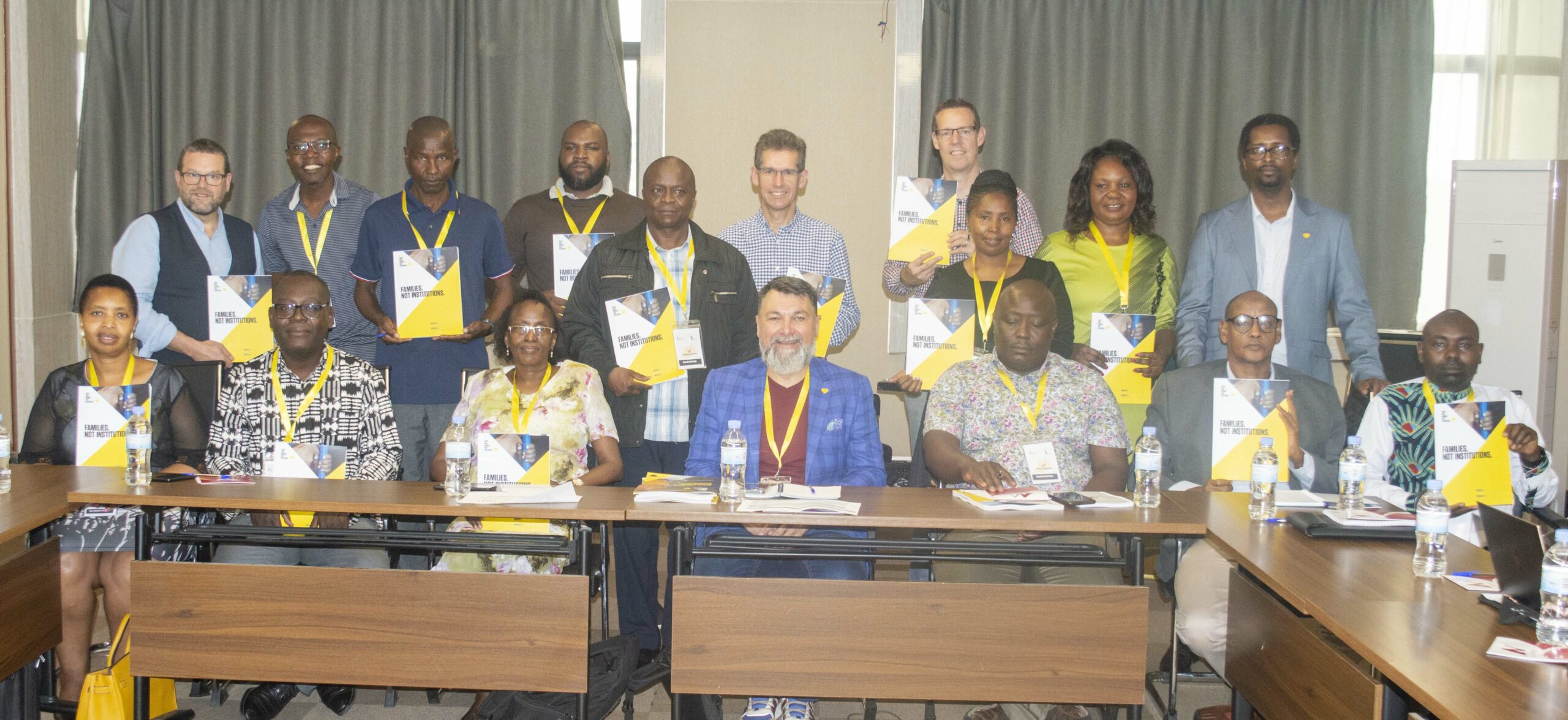 Group of Kenyan and Rwandan representatives smiling around a conference table