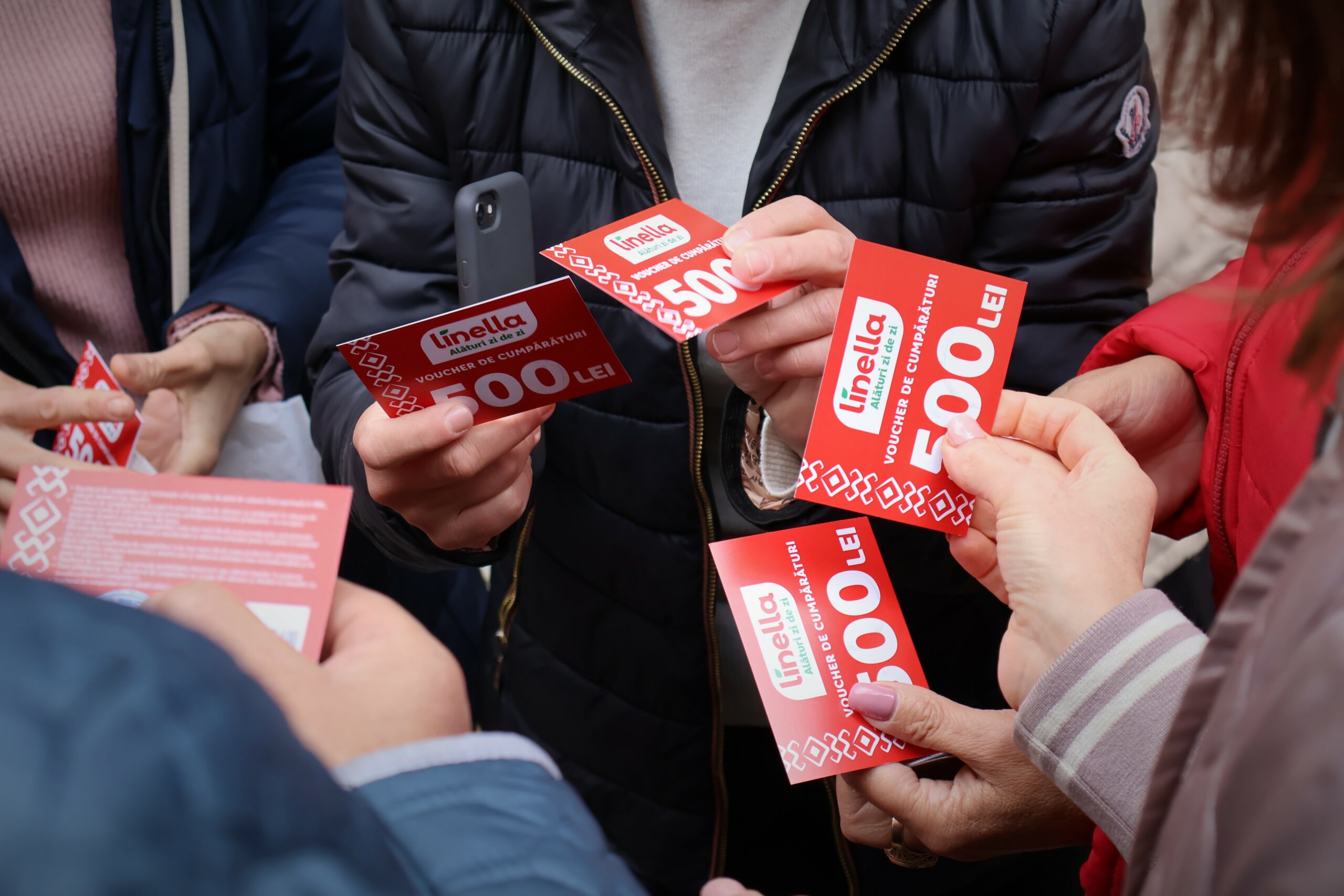 Female social workers hold red food vouchers for distribution to foster families in Moldova