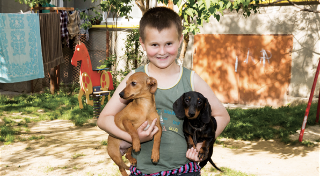 Young boy holding two boys smiling at camera