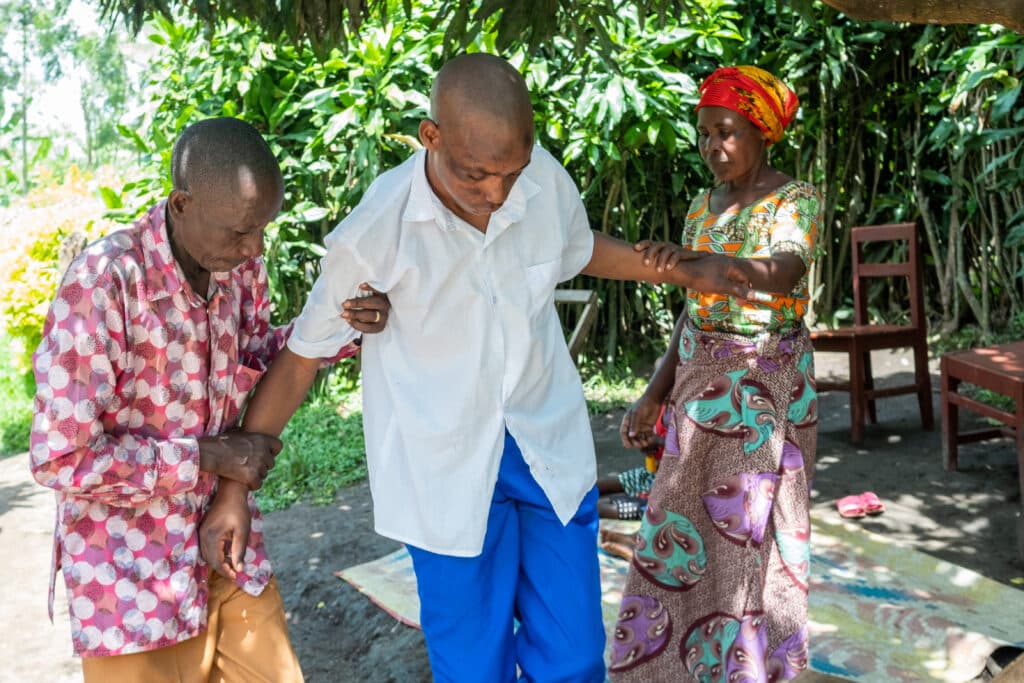 Image is of Rugwiro* caring for Ndoli* when he was
feeling weak after having a seizure