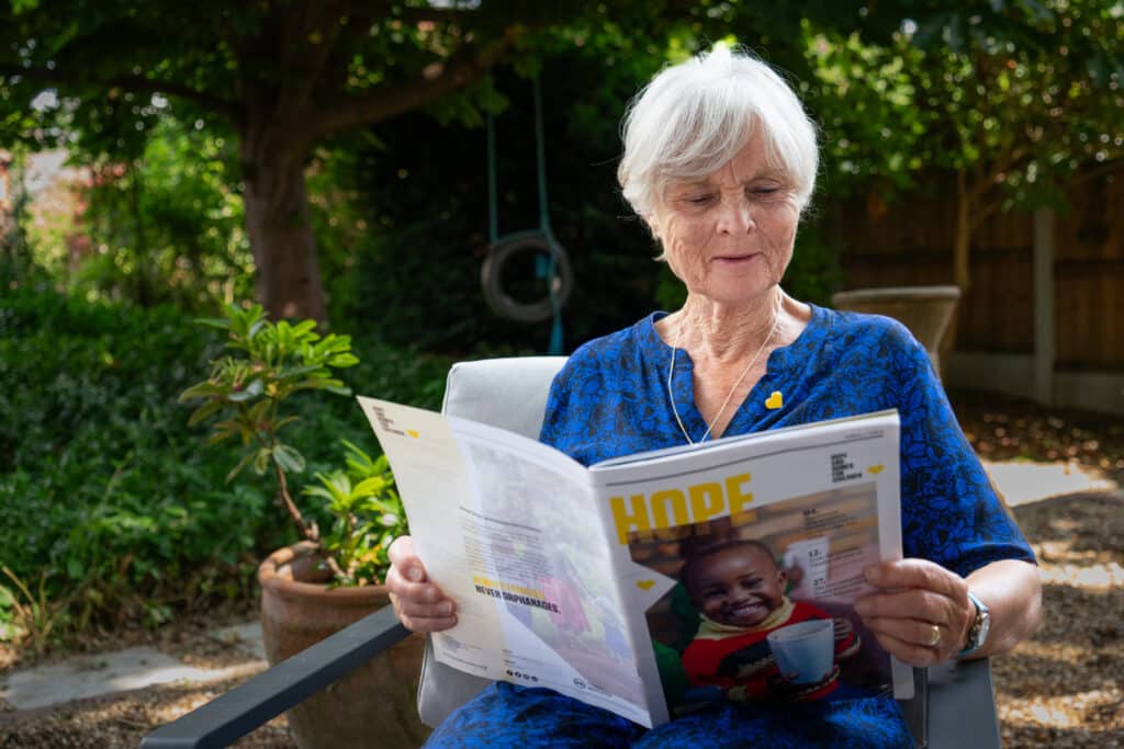 Wendy reading her latest issue of Hope at home in her garden.