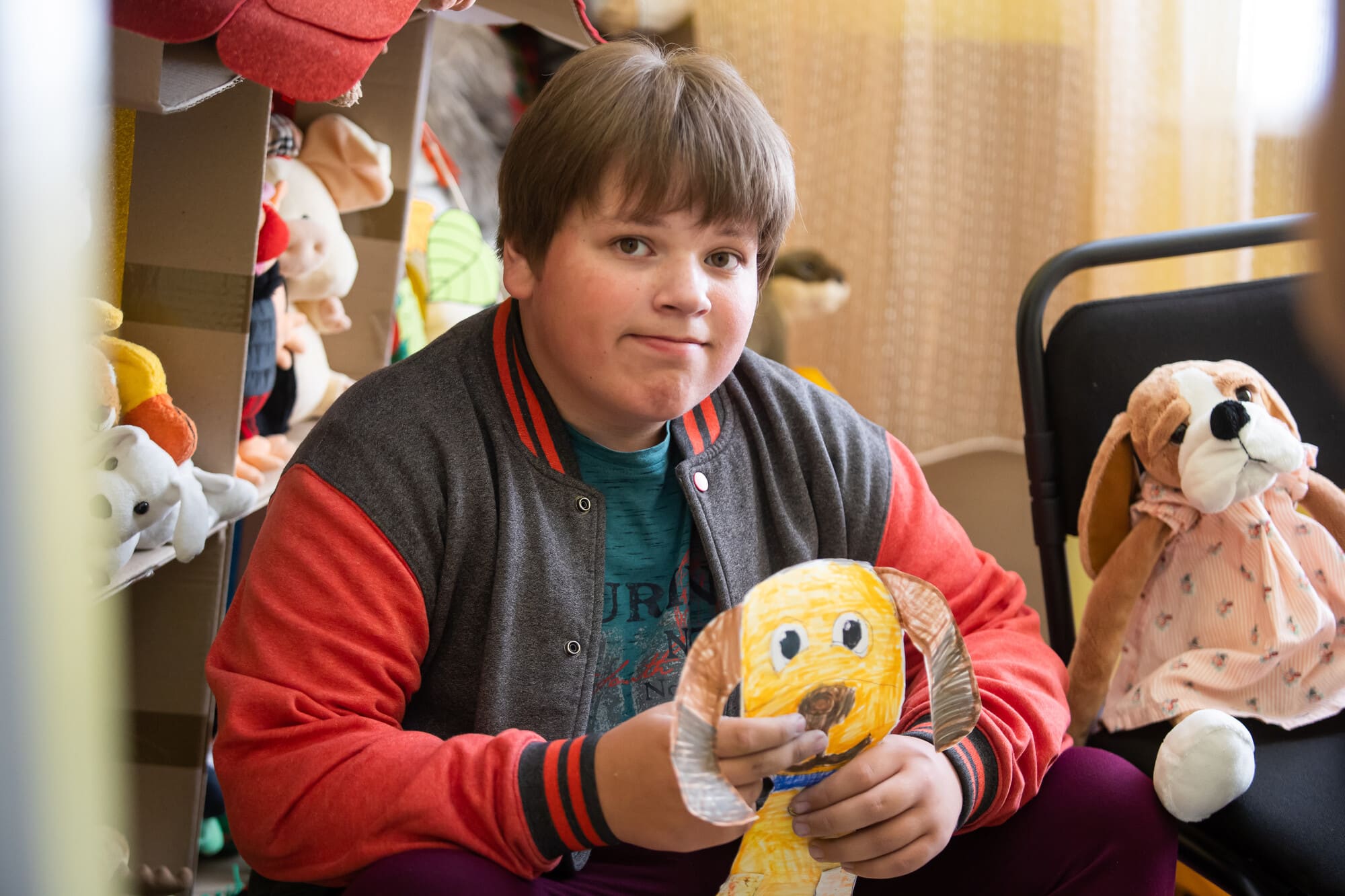 Andrii*, a Ukrainian boy with autism, clutches his drawing of a hibuki dog