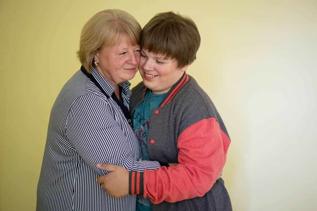 Ukrainian mum Ryta* hugs her son with autism, Andrii*, warmly