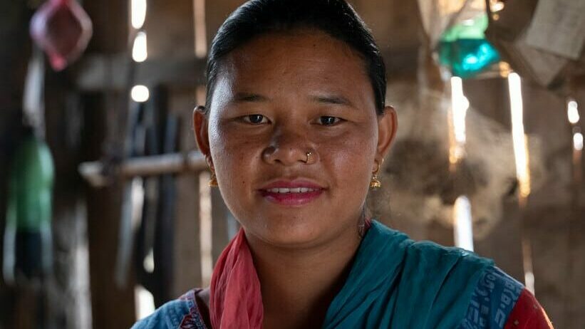 Lata, Sunil's mum, is from the indigenous Chepang community in Nepal. She smiles in her home, happy after having her son brought back home from an orphanage.