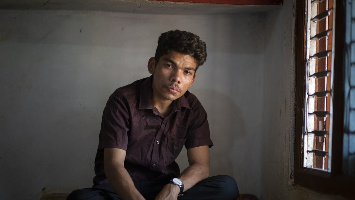 Moti* sitting on his bed