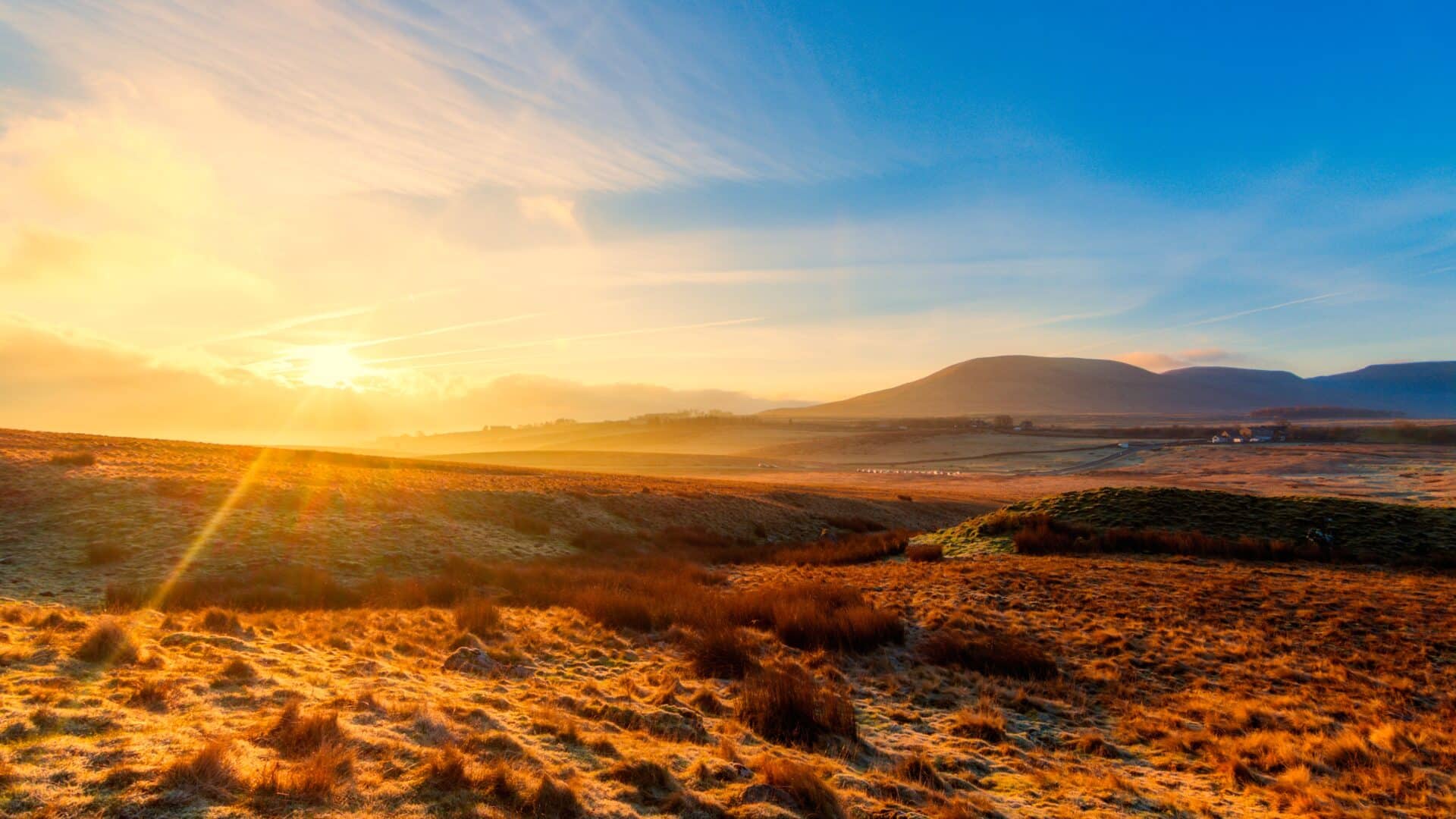 A glorious sunrise in the heart of the yorkshire dales with crisp blue skies and the mountains in the distance