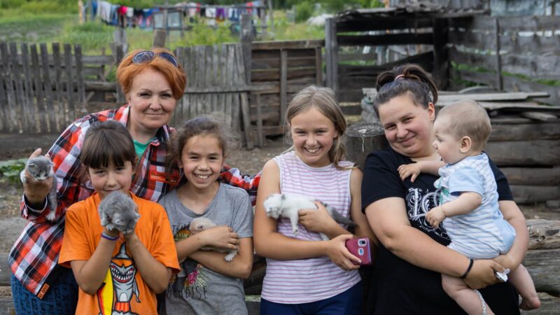 Tina's family posing together holding their pet kittens.