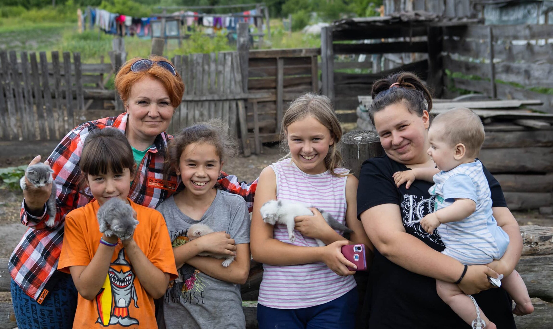 Tina's family posing together holding their pet kittens.