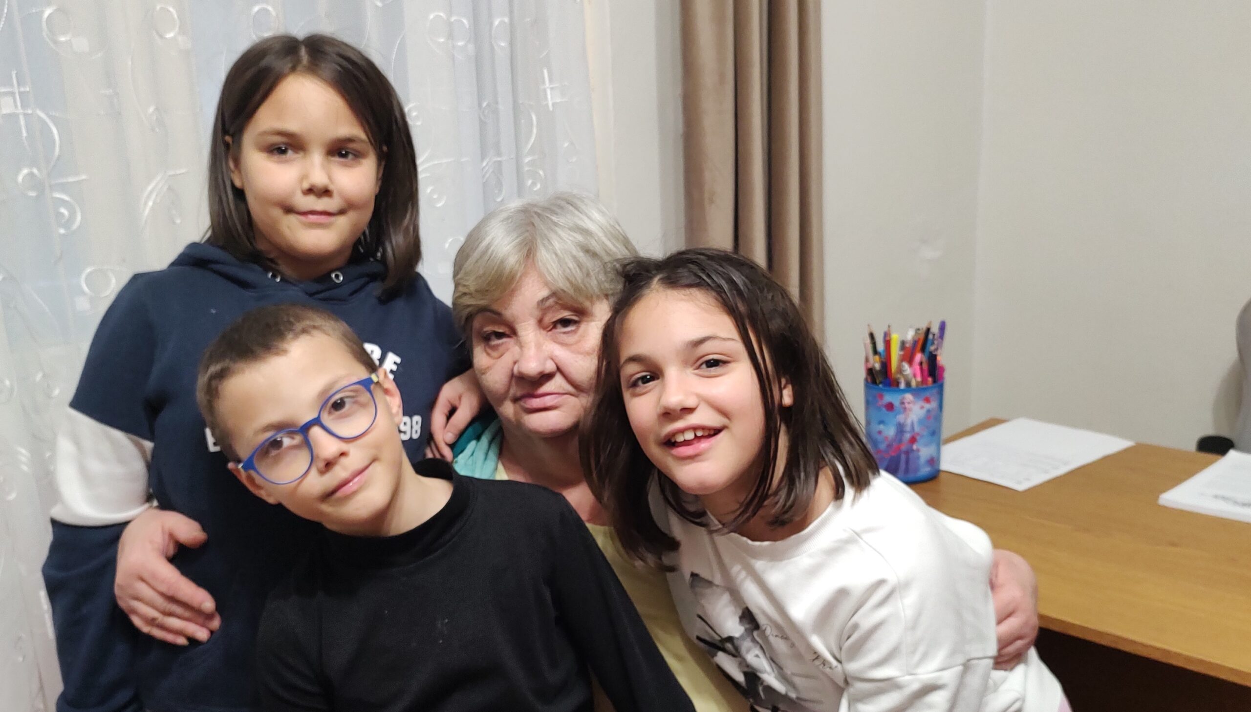 The three children. cuddle their grandmother